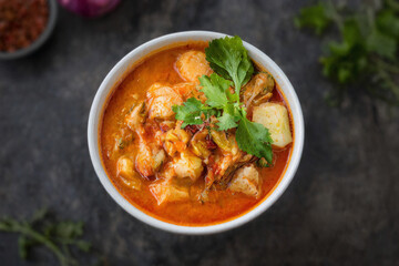 A vibrant bowl of spicy Thai red curry featuring creamy coconut milk, fresh vegetables, and aromatic herbs. For photo presentation, food promotional