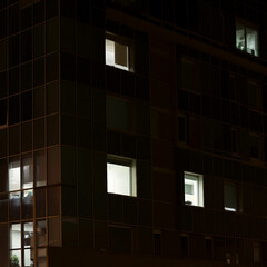 exterior of a building at night time lights on of an office building personnel staying late overtime