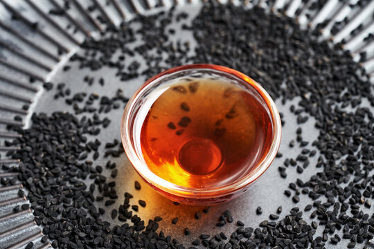 Black cumin or Nigella sativa seed oil in a glass bowl. Healthy anti-inflammatory and antioxidant supplement.