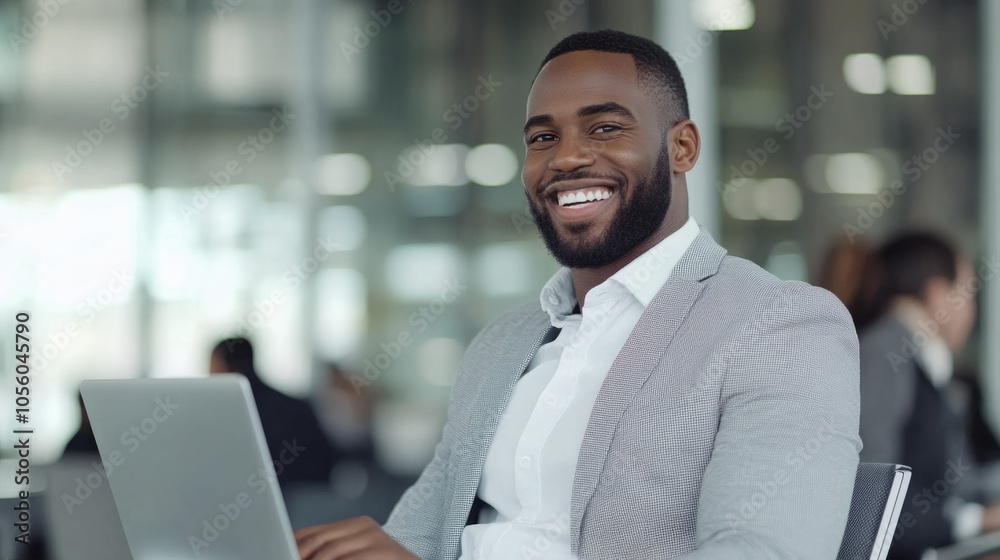 Poster a man with a big smile is sitting in front of a laptop
