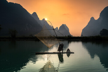 Villagers go fishing in Phong Nam Valley. Sunrise on a misty morning in Cao Bang, Vietnam.