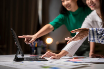 Two women are looking at a computer screen and pointing at something