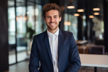 Fototapeta premium Smiling portrait of a young Caucasian businessman in modern office