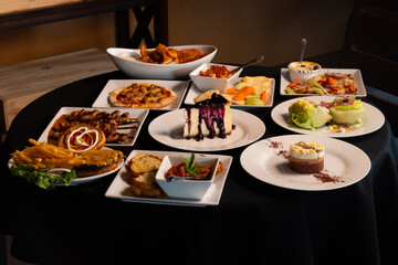 White Plates Of Delicious Food Setting On A Black Table Cloth