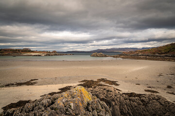 A cloudy, autumnal HDR image of an empty Samalaman Bay with Samalaman Island in the background, Glenuig, Moidart, Lochaber, Scotland.