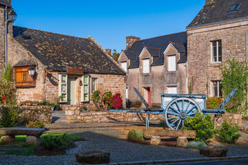 View of an idyllic little square, where an old freight car is located. Photography taken in Locronan, French Brittany, France.