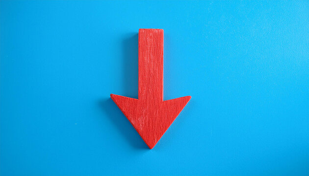 Red wooden arrow pointing down on blue background. Business, market decline or economic