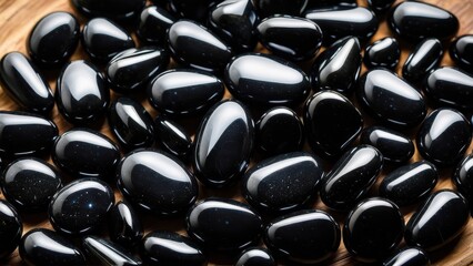 Glossy apache tears stones in varied teardrop shapes. These volcanic gems symbolize emotional healing, making them perfect for stock images related to wellness or energy stones.