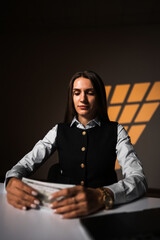 Woman holding a stack of dollars while working on a laptop. Accountant works with money. Concept of working in a bank. Credits and loans. Counting cash.Earnings online