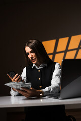 Woman holding a stack of dollars while working on a laptop. Accountant works with money. Concept of...