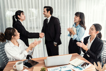 Group of businesspeople shake hand after made successful business agreement meeting. Diverse race office worker celebrate after made progress on marketing planning in corporate office. Meticulous