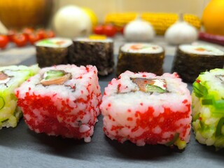 Delicious sushi rolls on a granite chopping board.