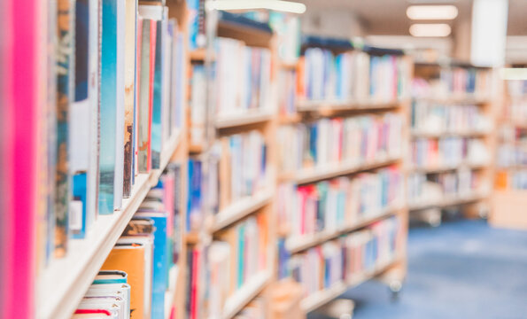 Public library interior blurred background. Aisle of a priceless library in UK, with thousands of books on its shelves.