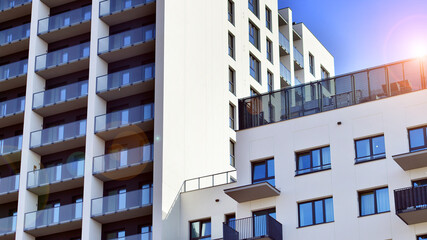 Modern high-rise apartment building  in white, stand tall against a blue sky, exemplifying...