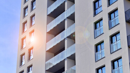 Modern high-rise apartment building  in white, stand tall against a blue sky, exemplifying...