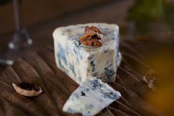 Blue cheese lies on a wooden board on a table