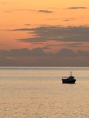 Obraz premium fishing boat at sunset