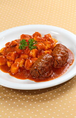 gnocchi with braciola in tomato sauce on plate