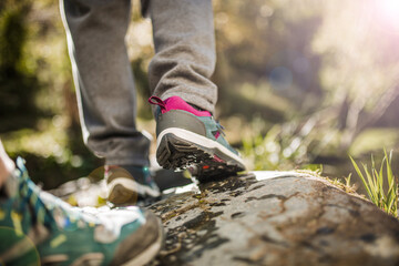 Two people hiking on wet rock near a river