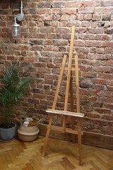 Minimalist Home Studio Setup with Brick Wall and Wooden Easel, High-Quality Background