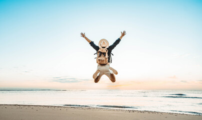Happy tourist enjoying sunset on the beach - Successful man jumping outside - Summertime holidays...