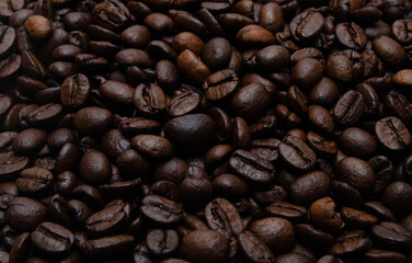 A pile of coffee beans. All stacked together, waiting to be ground into a delicious cup of coffee. A close-up shot of roasted coffee beans. Different types of delicious coffee beans.