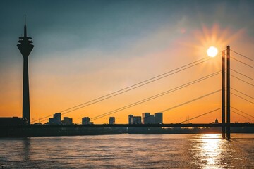 Fototapeta premium Bright sunset over the Rhine with Dusseldorf cityscape in the background, Germany
