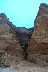 A rugged, towering rock formation stands majestically against a clear sky