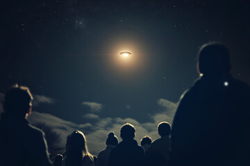 Obraz premium Mysterious glowing object in the night sky, with a crowd of people below, looking up in awe and disbelief, UFO and alien activity