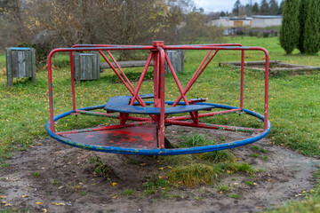 A carousel or merry-go-round in a playground. Old broken carousel on a playground