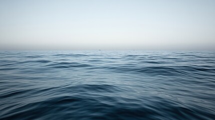 Obraz premium A vast expanse of blue ocean with calm waves and a distant ship on the horizon.
