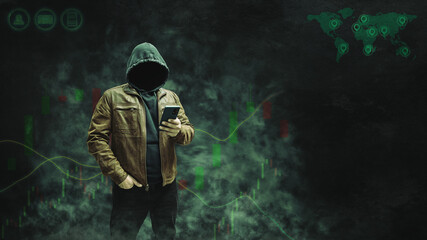 Faceless, anonymous hacker in a hoodie and leather jacket standing with a smartphone against a dark background featuring a forex or trading chart. Empty space for text, copy space