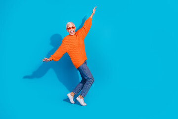Photo of carefree crazy old woman have fun raise hands fly wings plane isolated blue color background