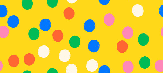 Whimsical seamless vector polka dot pattern with playful crayon spots and colorful confetti. Primary colored design for party or carnival yellow background.