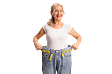 Happy middle aged woman trying on a pair of jeans, weight loss concept
