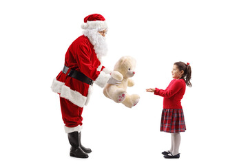 Santa Claus giving a teddy bear to a girl for christmas