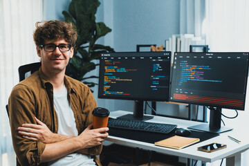 IT developer in online software development looking at camera and holding coffee cup surrounded...