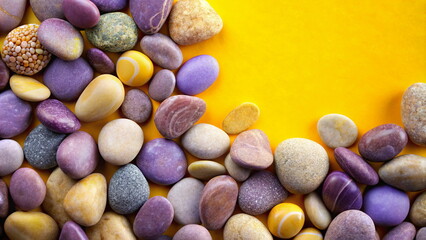 Colorful pebbles on vibrant yellow background