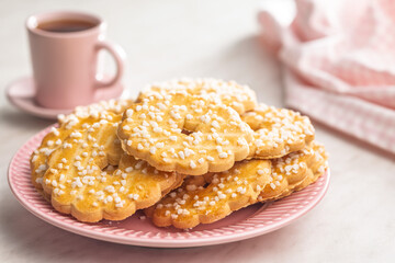 Sweet cookies in the shape of a flower. Tasty biscuits on plate on white table.