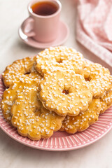 Sweet cookies in the shape of a flower. Tasty biscuits on plate on white table.