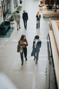Full length of male and female professionals walking at office lobby