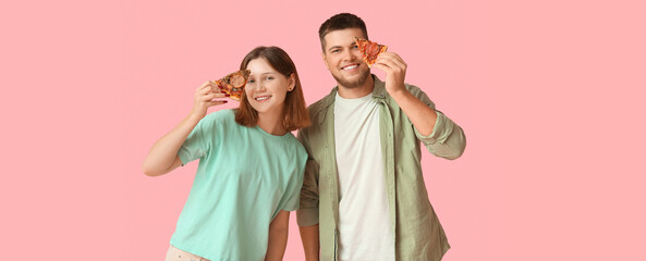 Beautiful young happy couple with pieces of tasty pizza on pink background