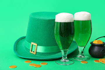 Glasses of beer with leprechaun hat and coins on green background. St. Patrick's Day celebration