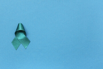 Teal ribbon on blue background. Sexual Assault Awareness Month