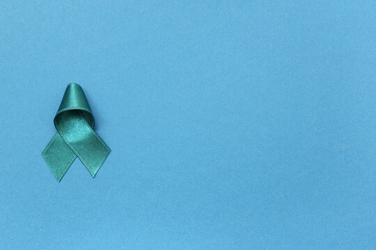 Teal ribbon on blue background. Sexual Assault Awareness Month