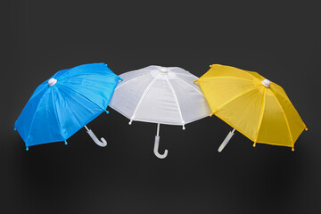 Different mini umbrellas on dark background