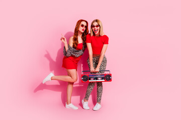 Photo of good mood positive girls wear stylish clothes celebrate event night club isolated on pink color background