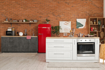 Interior of modern kitchen with red fridge, counters and shelf