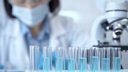Test tubes with a blurred scientist in a lab coat in the background
