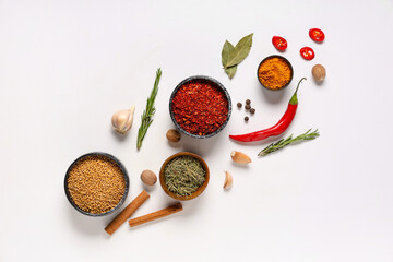 Different spoons and scoops with aromatic spices on grey background